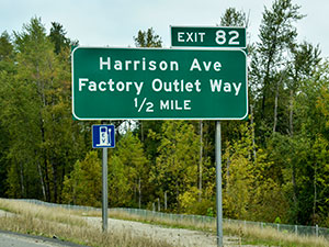 electric vehicle charging station sign on highway exit sign